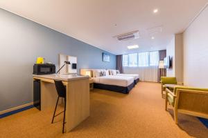 仁川市仁川机场戴斯酒店套房的大型酒店客房,配有一张床和一张书桌