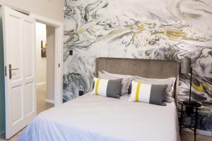 约翰内斯堡Melville Gap Guesthouse的卧室配有一张白色床,墙上挂有绘画作品