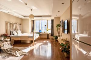天津天津G'公寓 - 五大道店的客厅设有床和大窗户