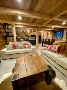 蒂涅chalet la grange的客厅配有两张沙发和一张木桌