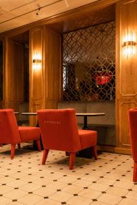赫梅利尼茨基Potocki Boutique Hotel的大堂设有红色椅子、桌子和柜台