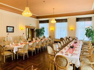 巴特施米德贝格普雷茨赫公园酒店的宴会厅配有长桌和椅子
