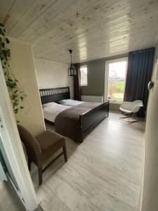 WanneperveenGroepsverblijf "De Klosse"的卧室配有床、椅子和窗户。