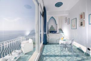 阿马尔菲拉宁法酒店的客房设有带桌子和床的阳台。