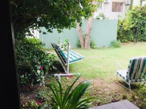 埃斯特角城圣雷莫蓬酒店 的一个带两把草坪椅和蓝色围栏的院子