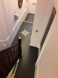 布鲁塞尔阿尔特德赛约住宿加早餐旅馆的楼梯铺着黑色的地板,地板上挂着星条
