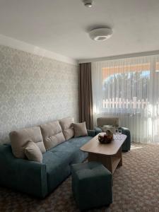 韦林格勒Balneo & SPA Hotel Aura的客厅配有蓝色的沙发和桌子