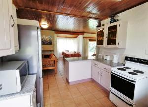 温特顿L Chiam Self-Catering Cottage的厨房配有白色橱柜和炉灶烤箱。