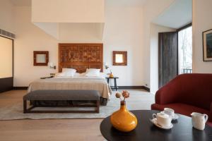 莱昂Parador de Turismo de León的一间卧室,配有一张床和一张桌子上的花瓶