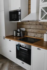ReuskulaForrest Lodge Karelia的厨房配有白色橱柜和炉灶烤箱。