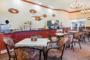 雷德迪尔华美达马鹿旅馆及套房的餐厅内带桌椅的用餐室