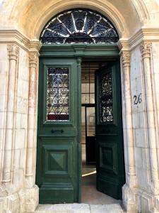 拉纳卡Le Mat Hostel的大楼内带窗户的绿色门