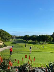 阿尔布费拉Algarve Luxury Experience - Situated within the Pinecliffs Resort的一群人在高尔夫球场打高尔夫