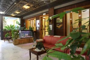 罗马匹考尔安切勒迪克里斯托雷旅馆的客厅配有红色沙发和电视
