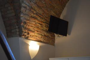 韦诺萨Dimora Sole Raggiante的砖墙旁边的墙上的电视机