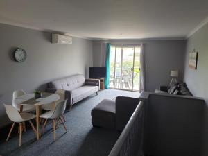 科夫斯港Aqualuna Apartments的客厅配有沙发和桌子