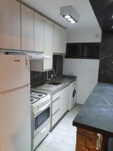 科尔多瓦Alojamiento Maria :-)的厨房配有白色橱柜和炉灶烤箱。