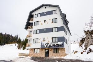 亚霍里纳Apartmani Kamavu的雪上标有标志的建筑