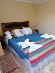 圣佩德罗·德·阿塔卡马Hostal Illari的一间卧室配有带毛巾的床