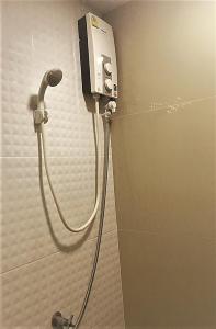 暖武里府Boom inn的浴室设有淋浴,墙上配有电话