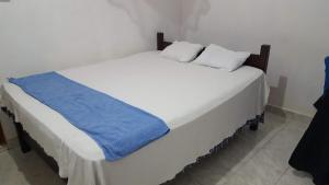 TanamalwilaTharuka Rest Inn Hotel的一张白色的大床,上面有蓝色的毯子