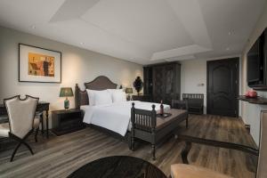 宁平Lalita Boutique Hotel & Spa Ninh Binh的卧室配有一张白色大床和一张书桌
