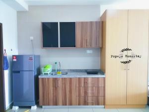 新山Luxury Premium Suite @ Kempas Johor Bahru的厨房配有蓝色冰箱和木制橱柜。