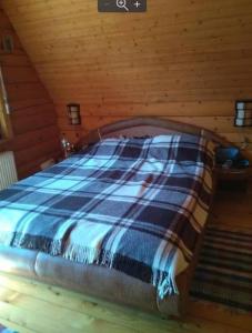 Dolishniy ShepitЕко садиба в Карпатах Лостун的木制客房内的一间卧室,配有一张床
