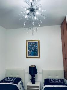 索马伦巴多CASA DEI FIORI的一间卧室配有两张床和吊灯。
