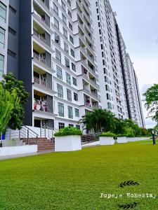 新山Luxury Premium Suite @ Kempas Johor Bahru的一座大型公寓楼,前面设有绿色草坪
