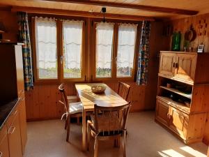 因内特基尔兴Chalet Am Fels的厨房配有木桌、椅子和窗户。