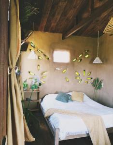拉佩德雷拉Raices del Mar的卧室配有两张床,墙上挂着鲜花。