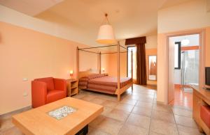 加利亚诺德尔卡波Il Tabacchificio Hotel的一间带天蓬床的卧室和一间客厅