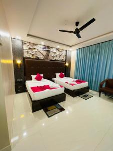 穆扎夫法尔普尔Blue Diamond Resort & Hotel的一间卧室配有两张床和吊扇