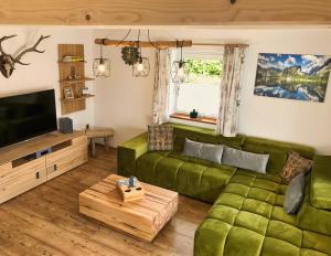 柯尼希斯湖畔舍瑙Ferienhaus Bergvagabund的客厅配有绿色沙发和电视