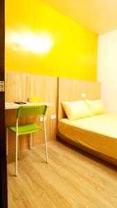 Chaozhou得恩典旅宿 的黄色客房,配有床、书桌和椅子