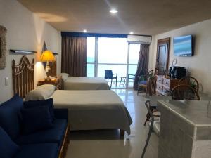 坎昆Salvia Cancun Aparts的一间卧室配有一张床,客厅配有沙发