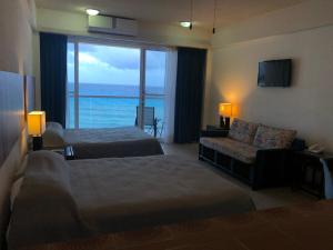 坎昆Salvia Cancun Aparts的酒店客房设有两张床、一张沙发和一个窗口。