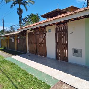 伯迪亚哥Casa de praia Bertioga SP Wi-Fi Fibra Home Office的一座带木栅栏和门的房子