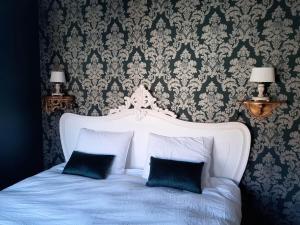 AlveringemVakantiehuis Louiselotte的卧室配有白色的床和2个枕头