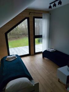 WielgieDom przy lesie的客房设有两张床和大窗户。