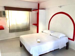 阿卡普尔科Hotel Maria Bonita Acapulco的一间卧室配有一张红色框架的白色床