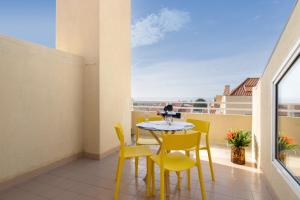 加亚新城Stunning Modern Flat w Terrace Miramar Gaia的小阳台配有桌子和黄色椅子