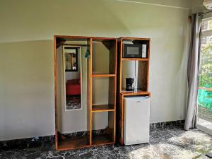 萨玛拉Tuki Tuki Lodge的客房设有书架、电视和冰箱。