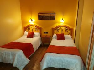 Villalón de CamposHotel Rural Venta Del Alon的黄色墙壁客房的两张床