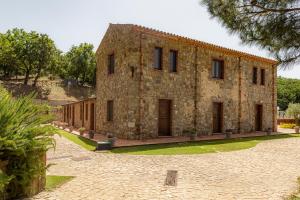 CollesanoCasena Mongerrati的一座大型石头建筑,前面设有一个庭院