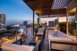 卡塔赫纳Oz Hotel Luxury的阳台配有白色家具,享有城市美景。