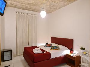 罗马我来借宿酒店的一间卧室配有红色的床和电视