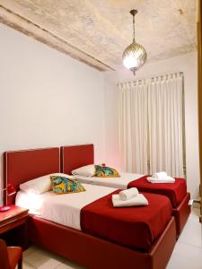 罗马我来借宿酒店的卧室设有两张红色和白色的床