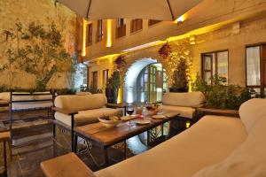 于尔居普Aja Cappadocia Cave Hotel的一座大楼内一个带沙发和桌子的庭院